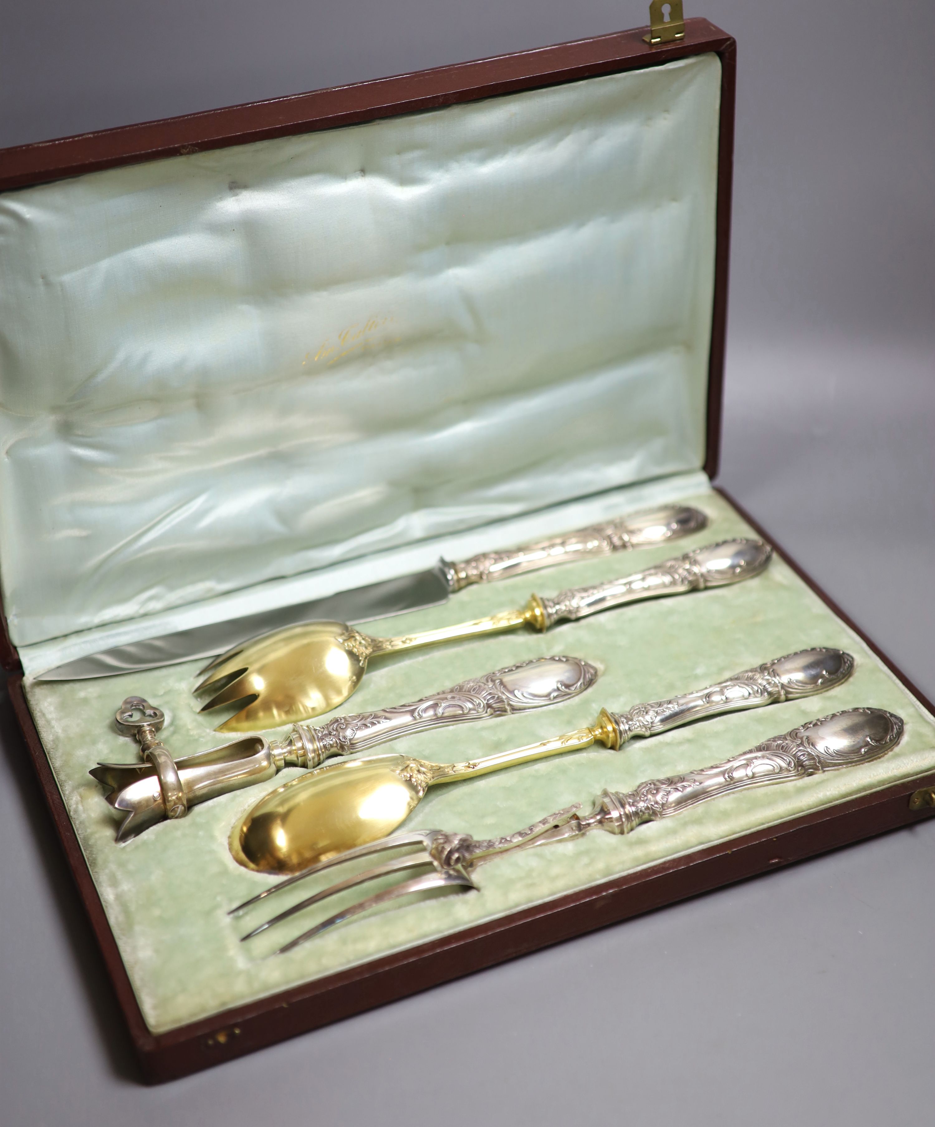 A cased early 20th century French five piece parcel gilt white metal and steel carving/serving set.